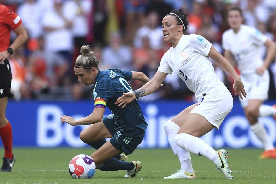 Almanya'dan Svenja Huth, solda, Kadınlar Euro 2022 finalinde İngiltere'den Lucy Bronze'a top için meydan okuyor.